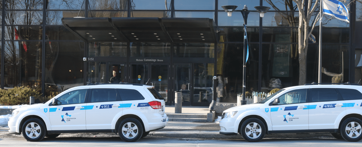 Federation CJA building with two white Community Security Network vehicles parked in front