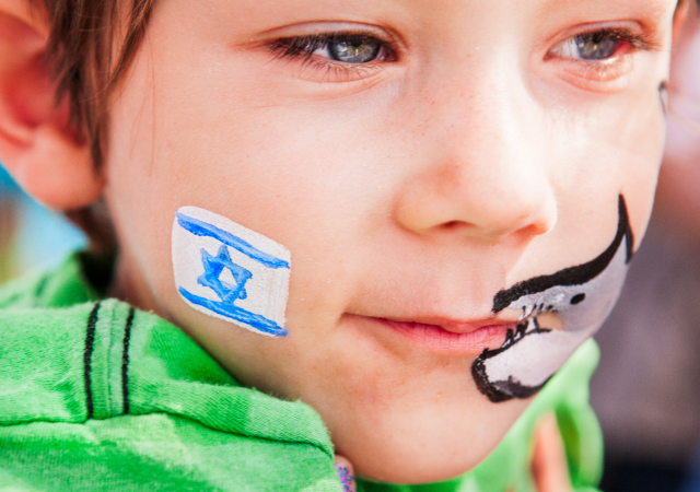 Jeune garçon avec un drapeau israélien et un requin peints sur le visage
